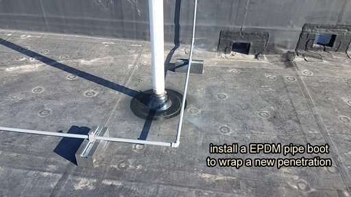 Pipe penetration in BUR Rolled Asphalt Modified Roof, has four voids at the base, with water pooled in the interior.