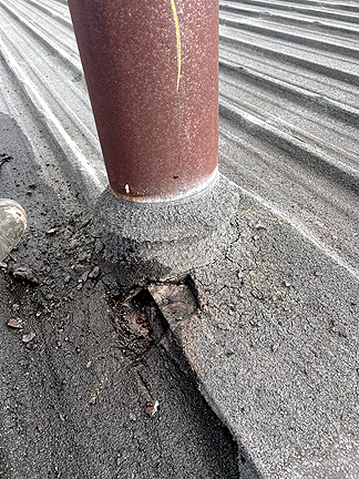 Pipe penetration in BUR Rolled Asphalt Modified Roof, has four voids at the base, with water pooled in the interior.