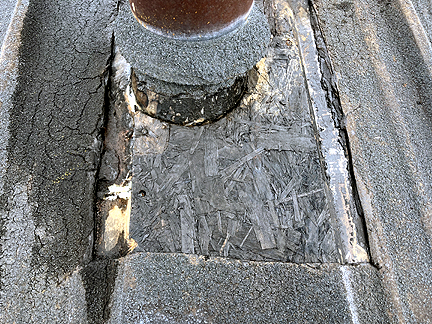 Pipe penetration in BUR Rolled Asphalt Modified Roof, has four voids at the base, with water pooled in the interior.