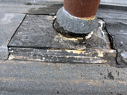 Pipe penetration in BUR Rolled Asphalt Modified Roof, has four voids at the base, with water pooled in the interior.